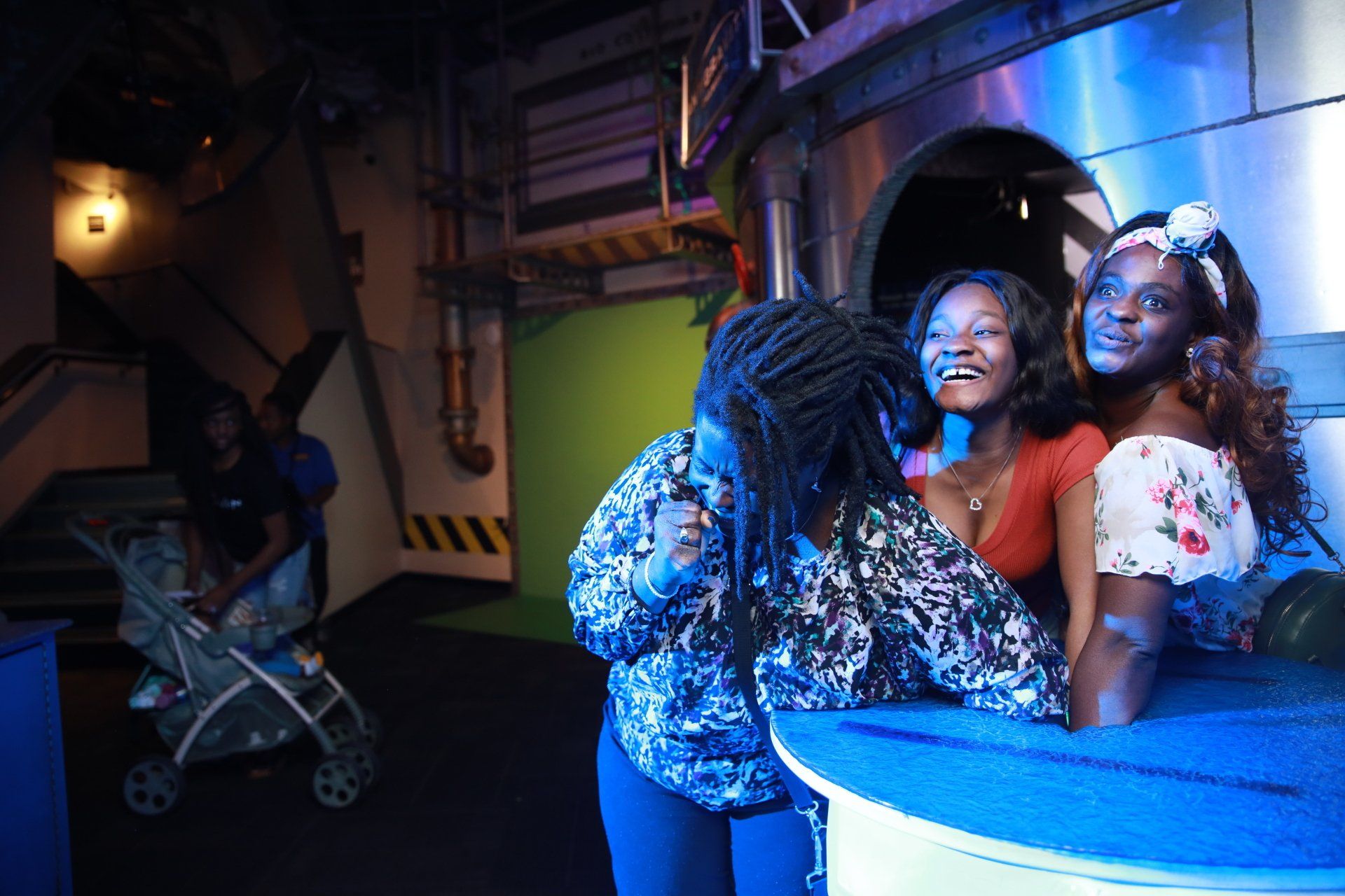 Three women are posing for a picture in a dark room.