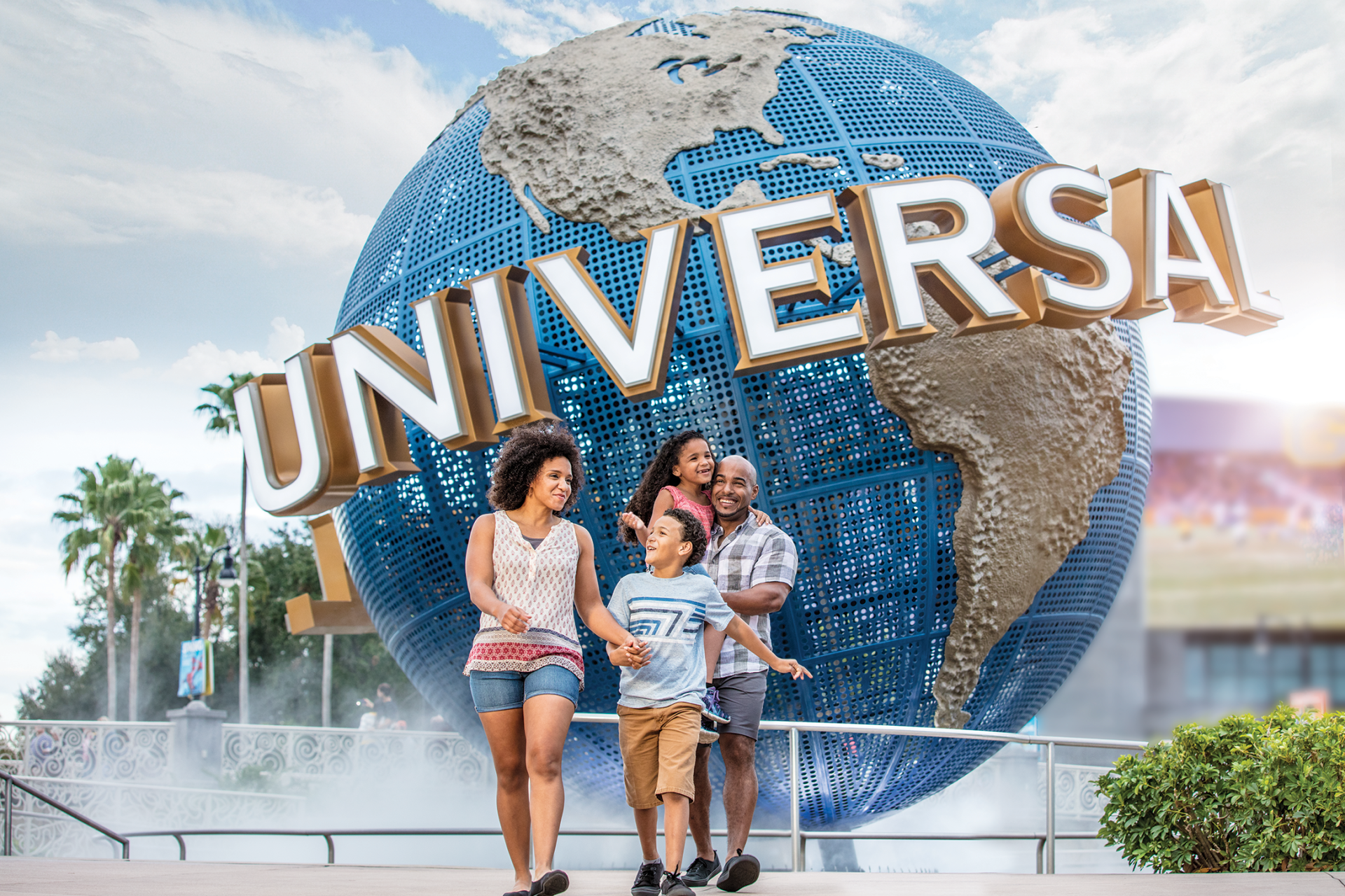 A family is standing in front of a giant globe at universal studios.