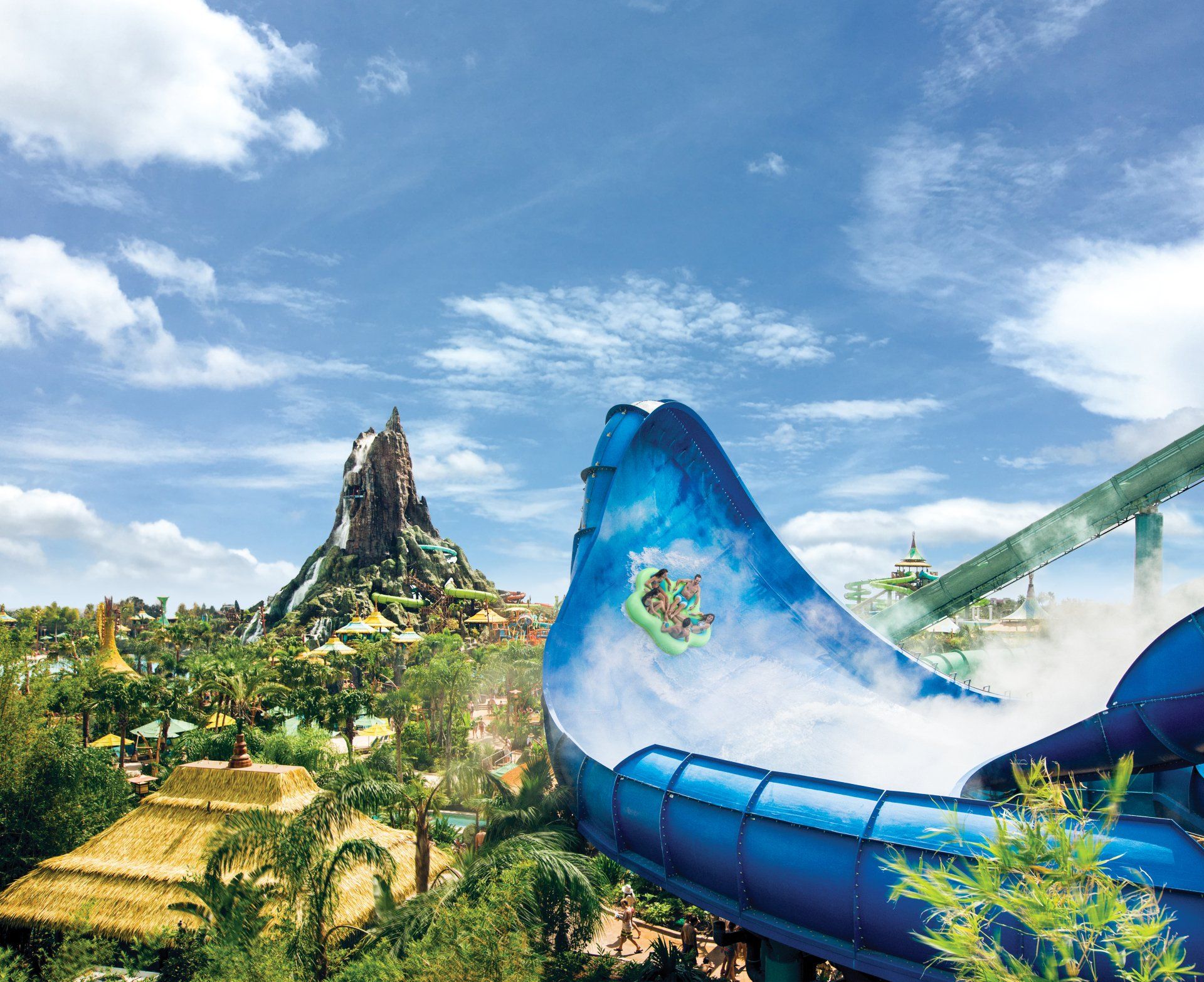 A person is riding a blue water slide at a water park.