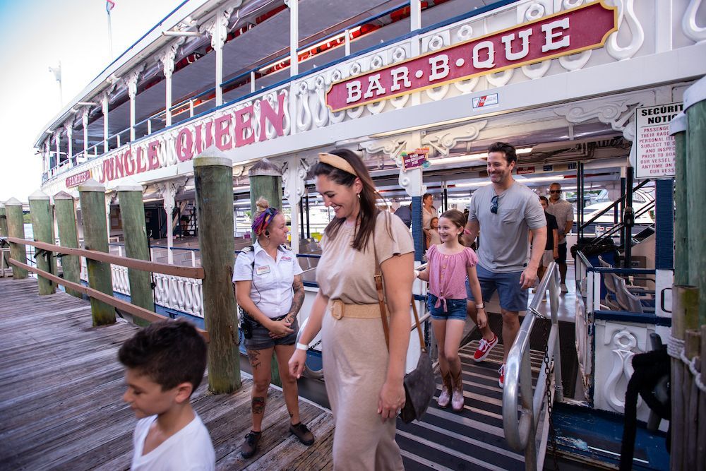 A family is boarding a boat on a dock.