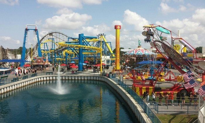 A large amusement park with a fountain in the middle of it.