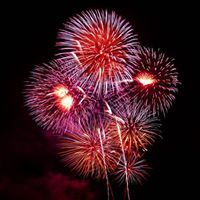 A bunch of fireworks are exploding in the night sky.