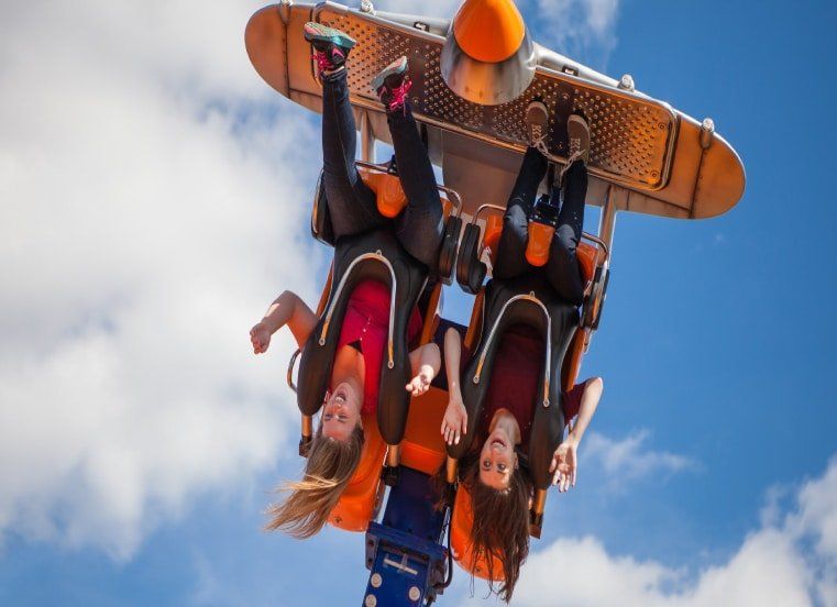 A group of people are flying through the air on a roller coaster.