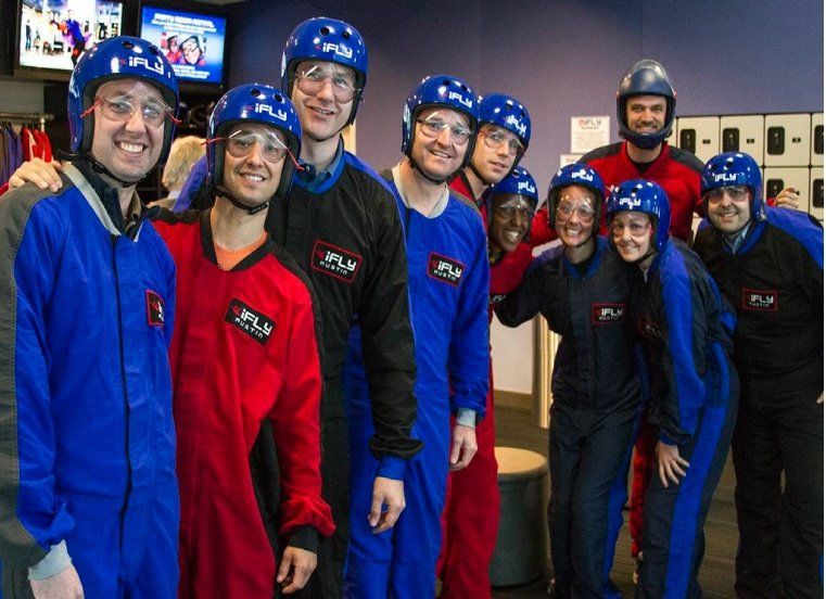 A group of people wearing jumpsuits and helmets pose for a picture