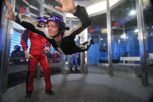 A man in a helmet is flying through the air in a room.