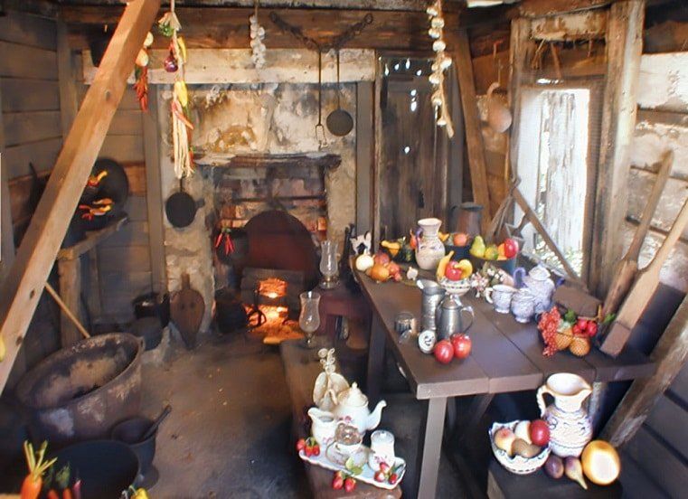 A kitchen with a table full of food and a fireplace