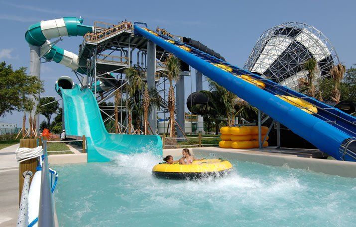 Two people are riding a tube down a water slide at a water park.
