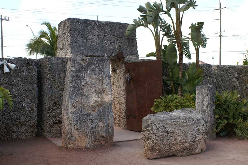 A stone wall is surrounded by plants and trees