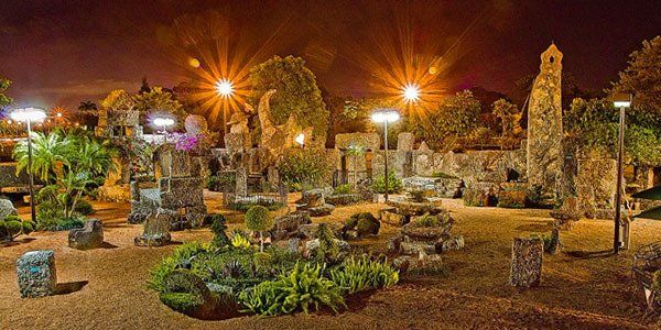 A cemetery with a lot of graves and trees at night.