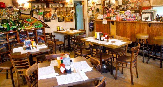 A restaurant filled with tables and chairs and a bar.
