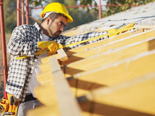 man measuring the roof
