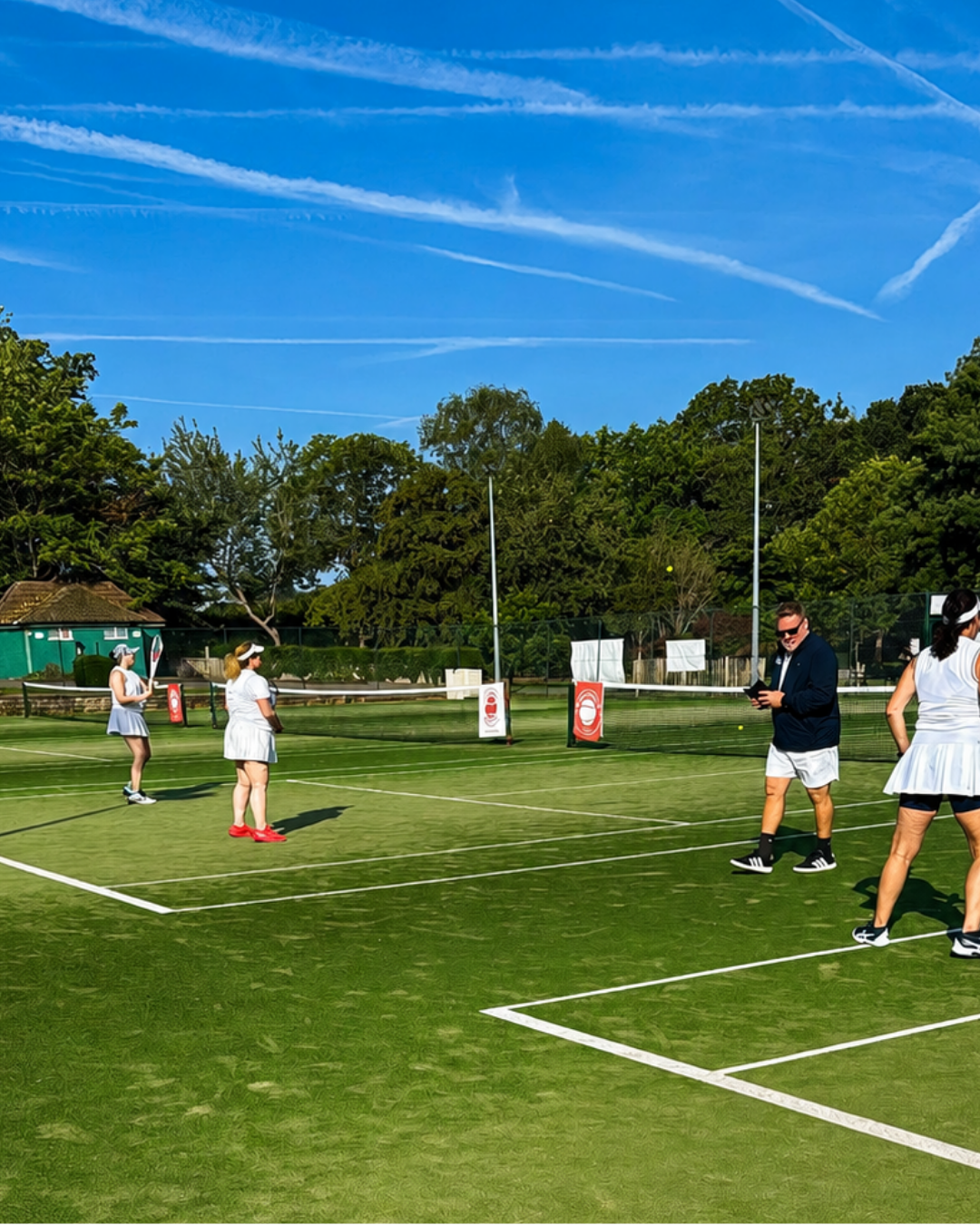 People playing a lawn game on a sunny green field under a blue sky