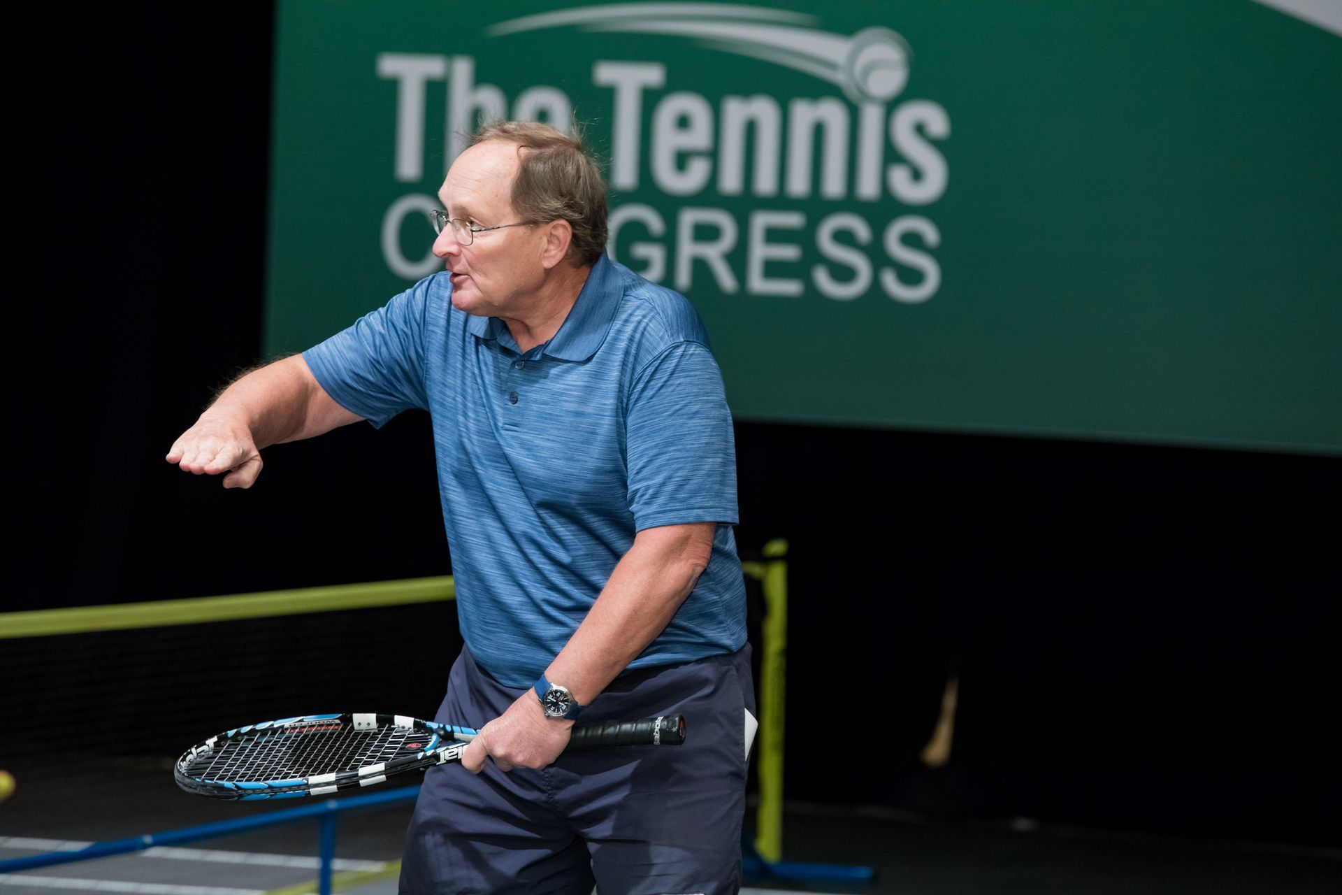 Man demonstrates tennis swing at 