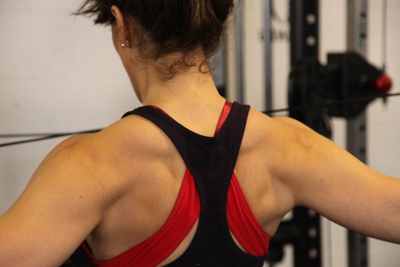 The back of a woman wearing a black and red sports bra