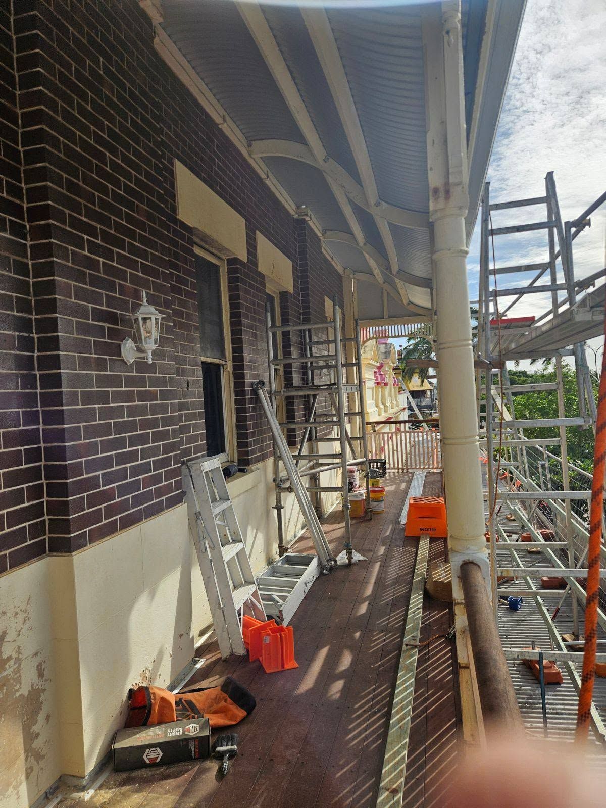 Narrow Brick Lined Porch Under Repair with Construction Materials Along the Walkway — Chops Painting in Coral Cove, QLD
