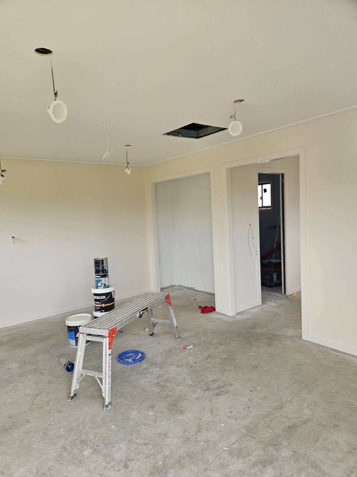 Empty Room Under Renovation with Unfinished Floor, Paint Supplies, and Open Doorway — Chops Painting in Coral Cove, QLD