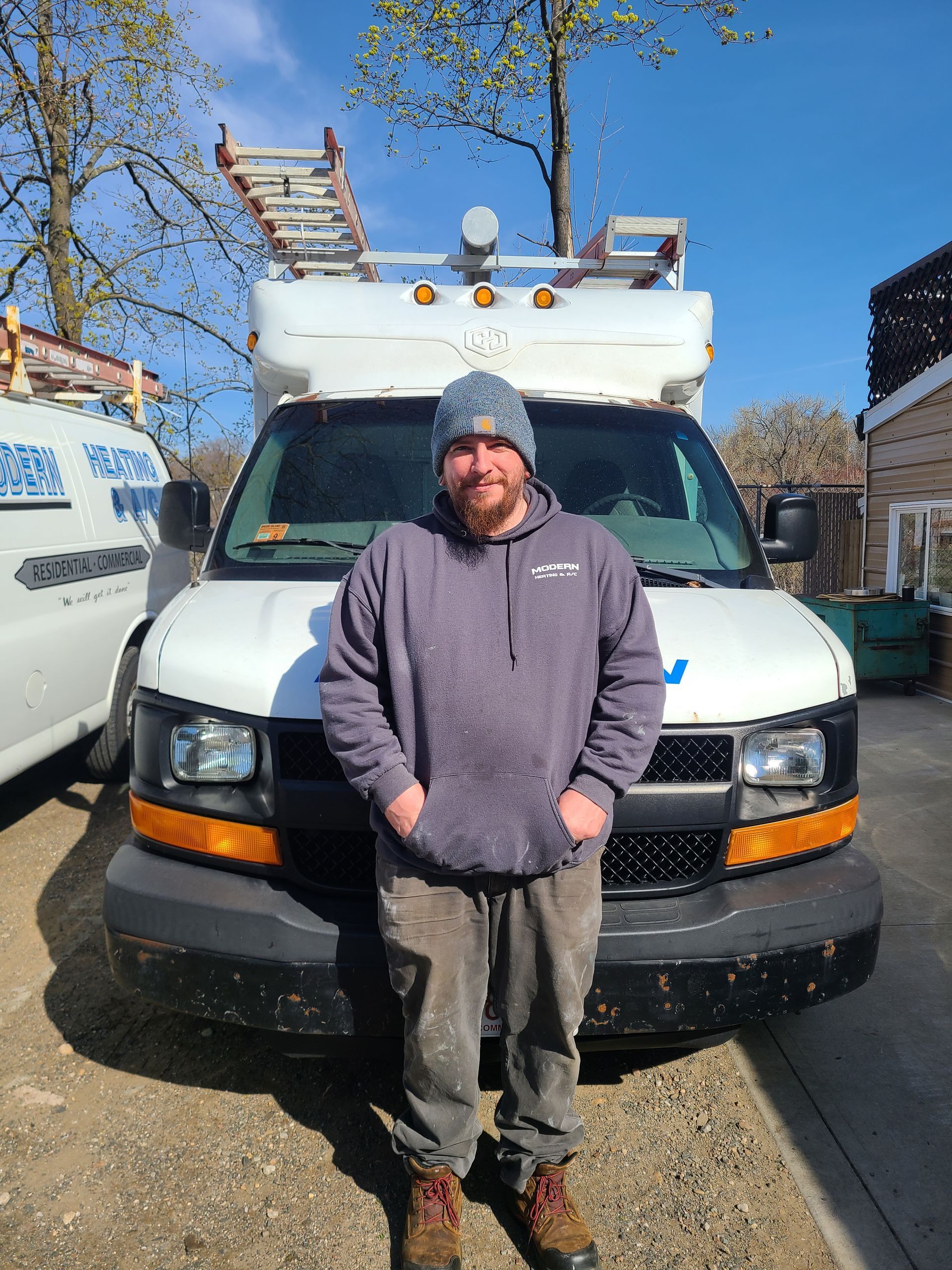 A man is standing in front of a white van.