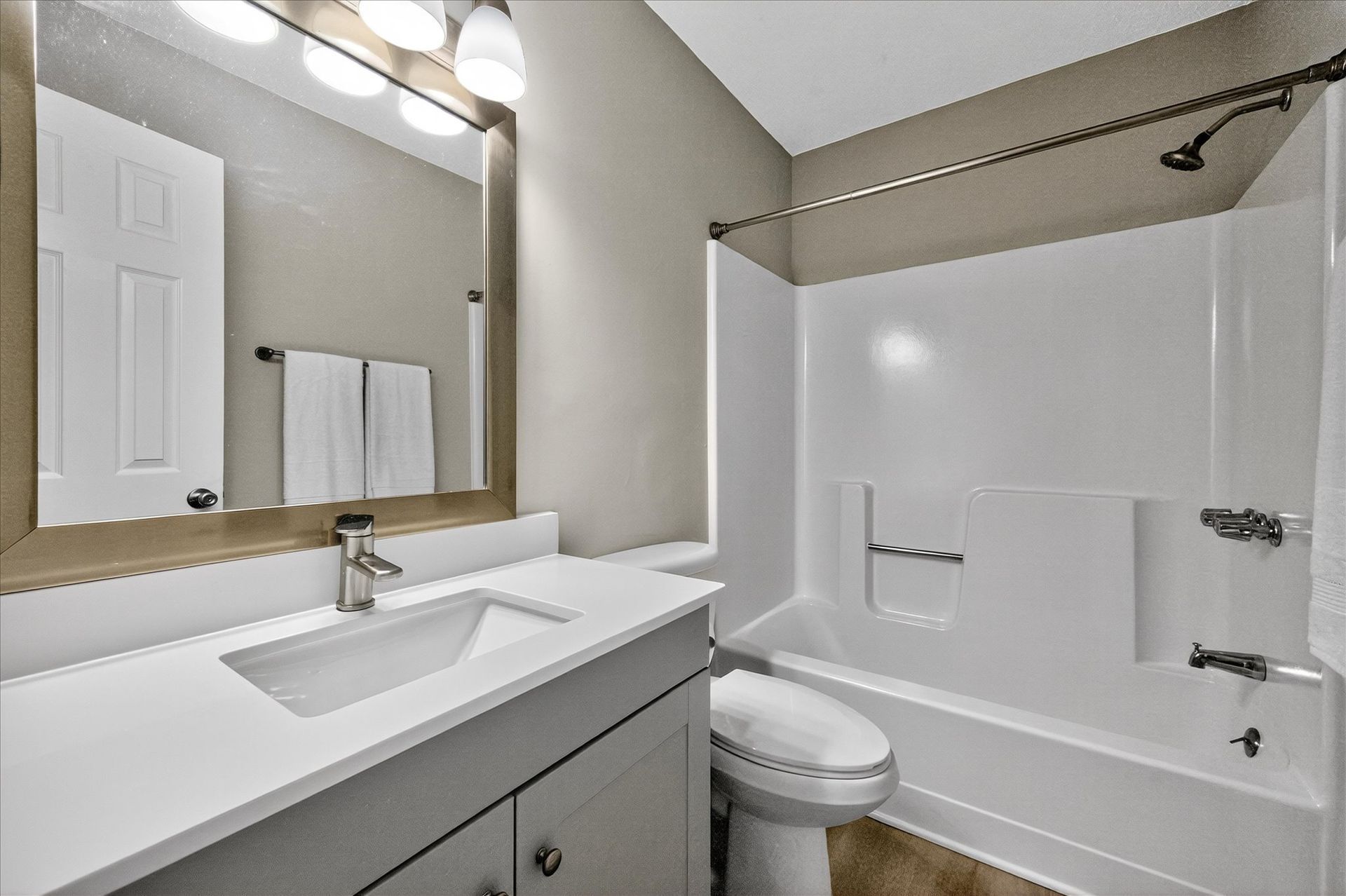 Bathroom with white vanity, mirror, toilet, and shower-tub combo with white curtain