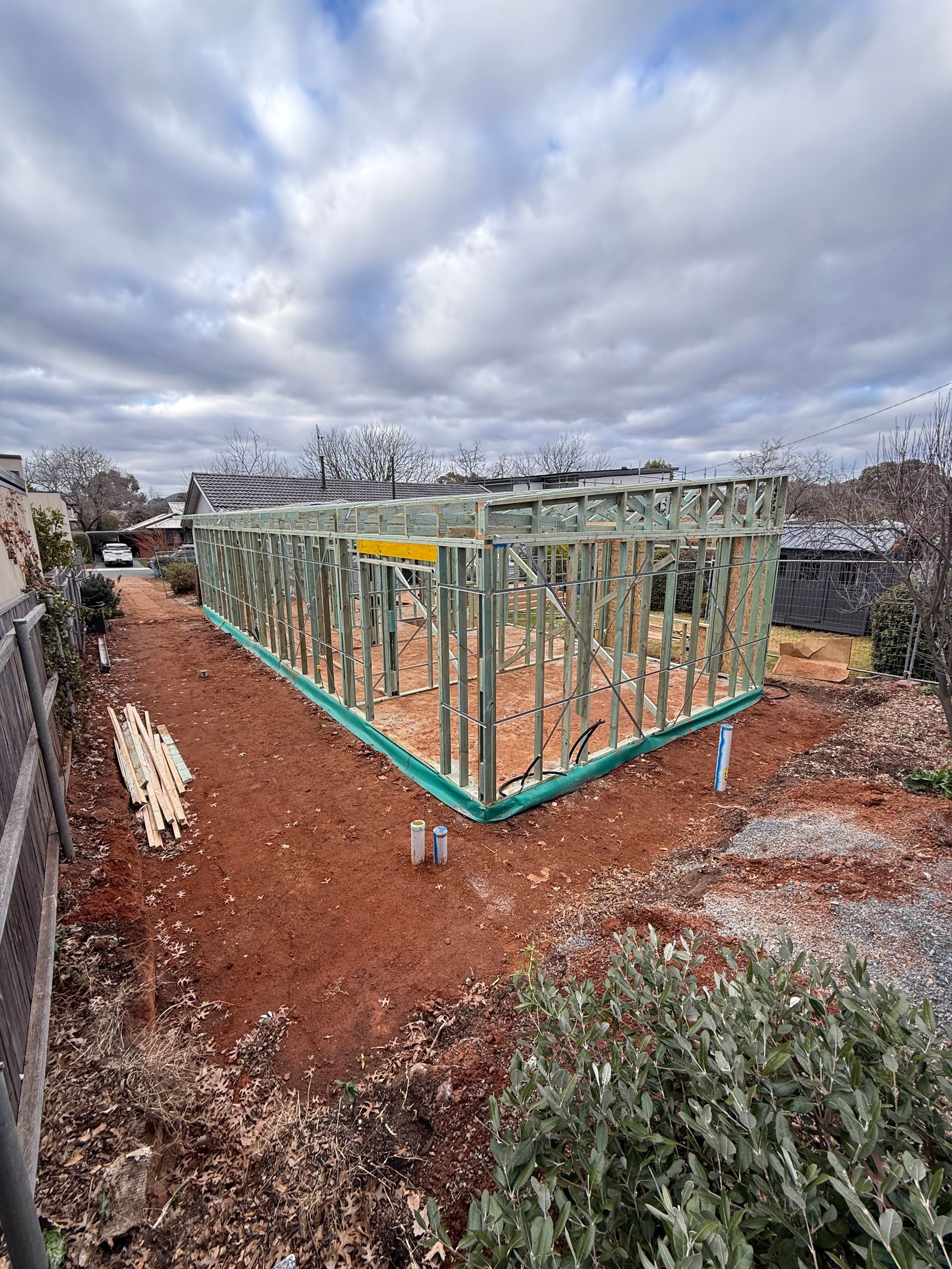A house is being built in the middle of a dirt field.