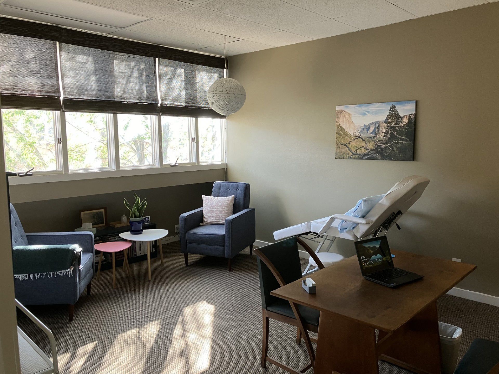 A room with a table , chairs , and a painting on the wall inside TMS New Mexico