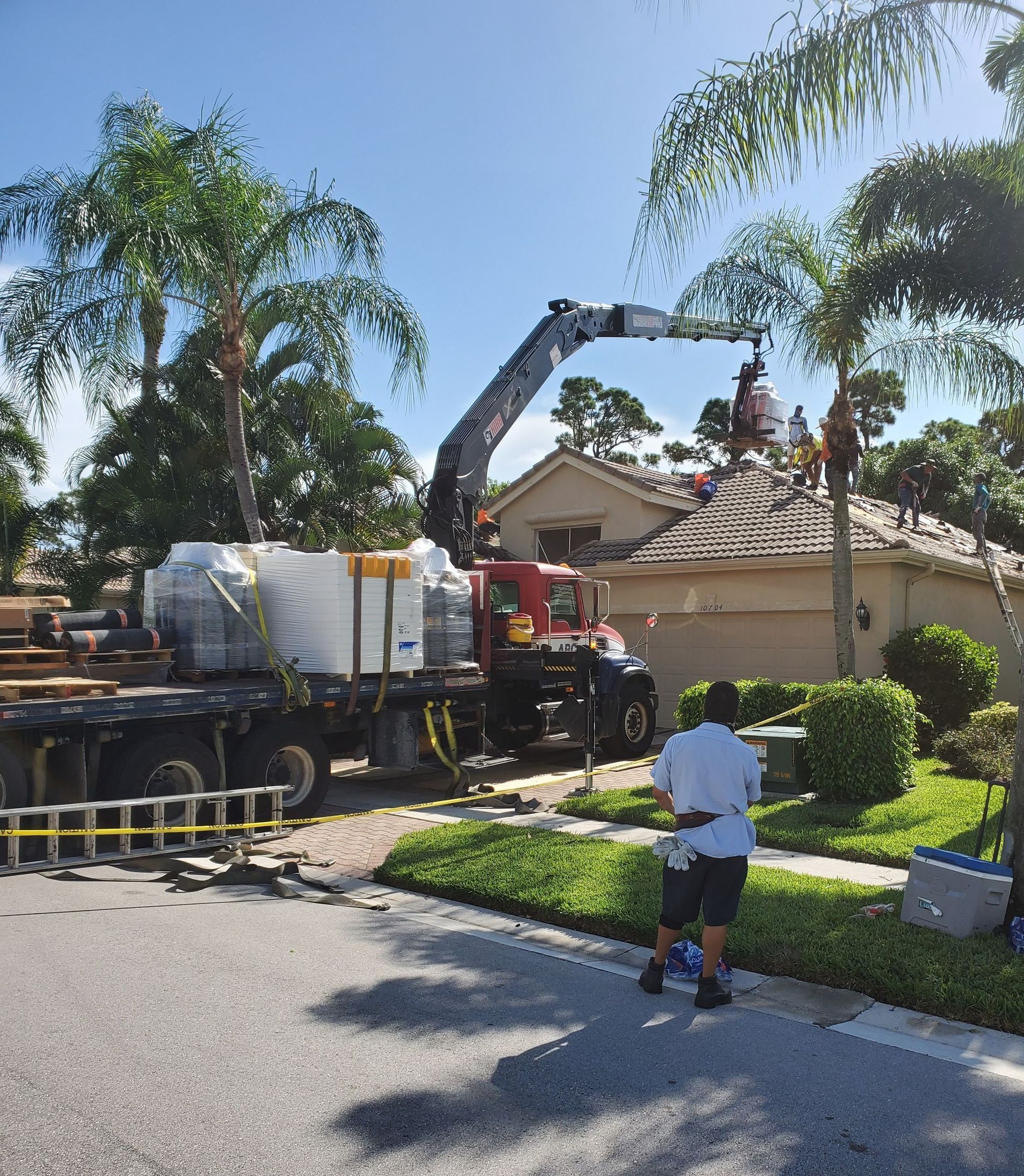 A man is standing in front of a truck with a crane attached to it.
