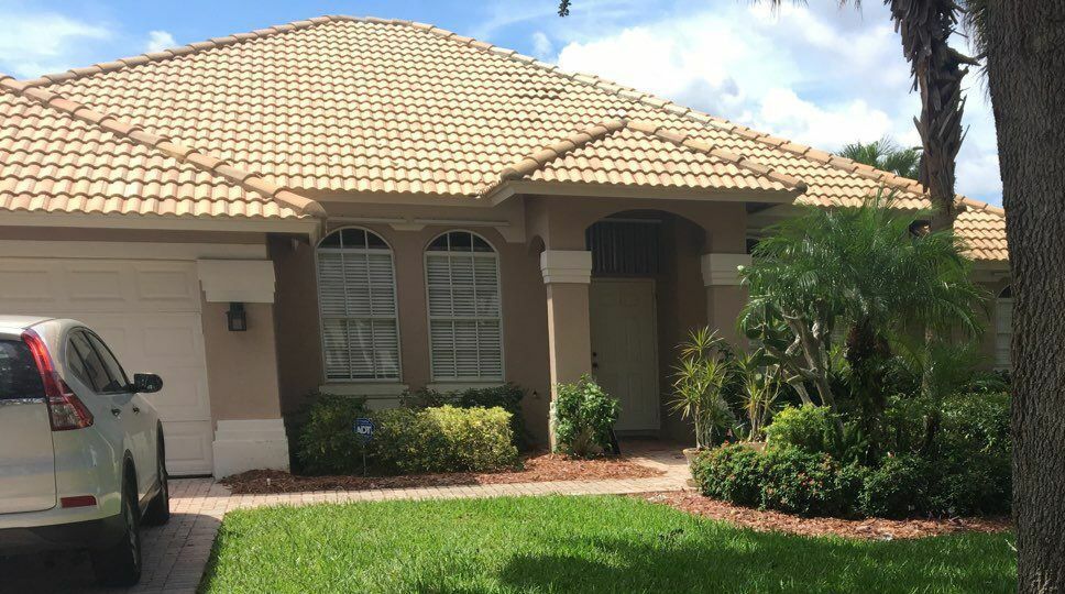 Heads Up Roofing Florida | A car is parked in front of a house with a tile roof.
