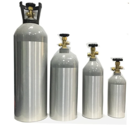Cuatro cilindros de gas plateados de diferentes tamaños sobre un fondo blanco.