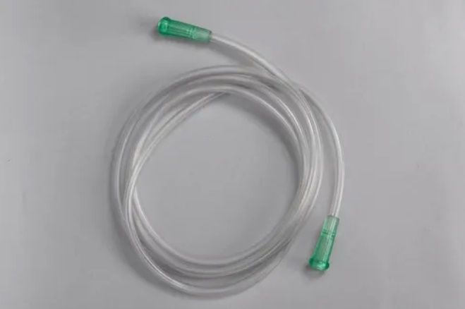 Tubo transparente enrollado con conectores verdes en ambos extremos.
