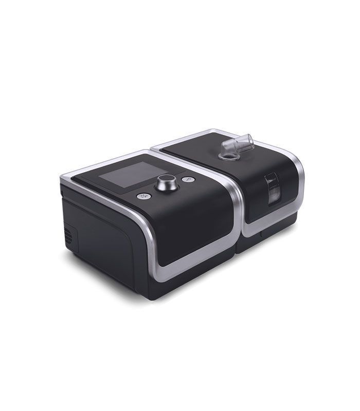 Máquina CPAP de sobremesa negra y plateada con pantalla digital y cámara humidificadora.