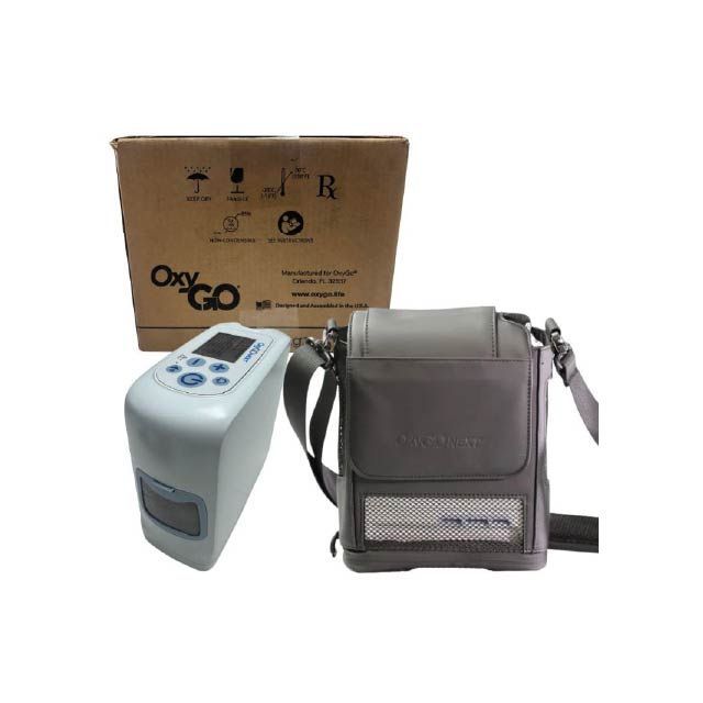 Concentrador de oxígeno portátil OxyGo con estuche y caja de transporte grises sobre fondo blanco.