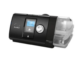 Máquina CPAP negra con pantalla digital y cámara humidificadora transparente sobre fondo blanco.