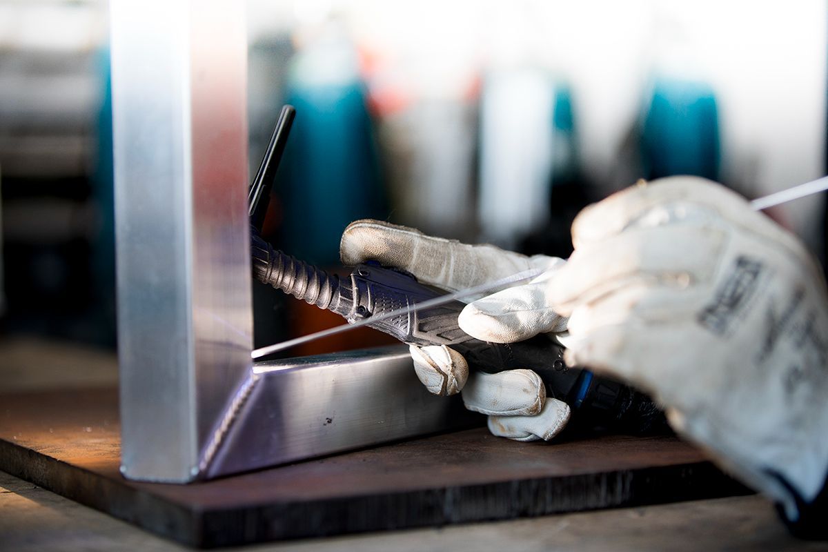 A person is welding a piece of metal on a table — Sheet Metal Fabrication In Caloundra, Qld