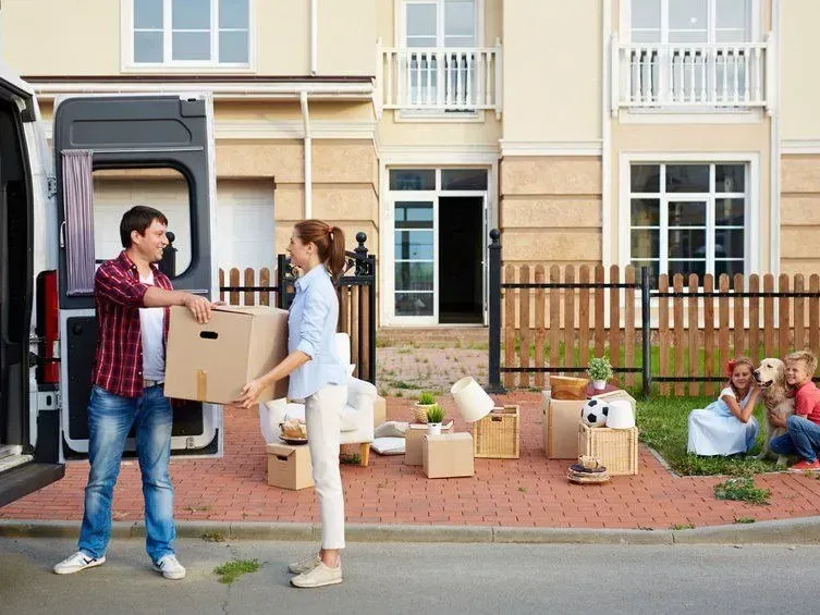 Man and Woman Moving Boxes from Van to House — Barnes Transport and Removals in Wardell, NSW