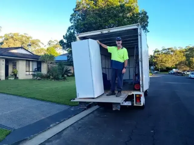 Man Standing in Back of Truck, Beside a Refrigerator — Barnes Transport and Removals in Wardell, NSW