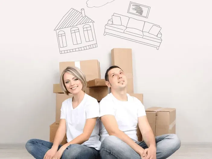 Couple Sits Back to Back in Front of Moving Boxes — Barnes Transport and Removals in Wardell, NSW