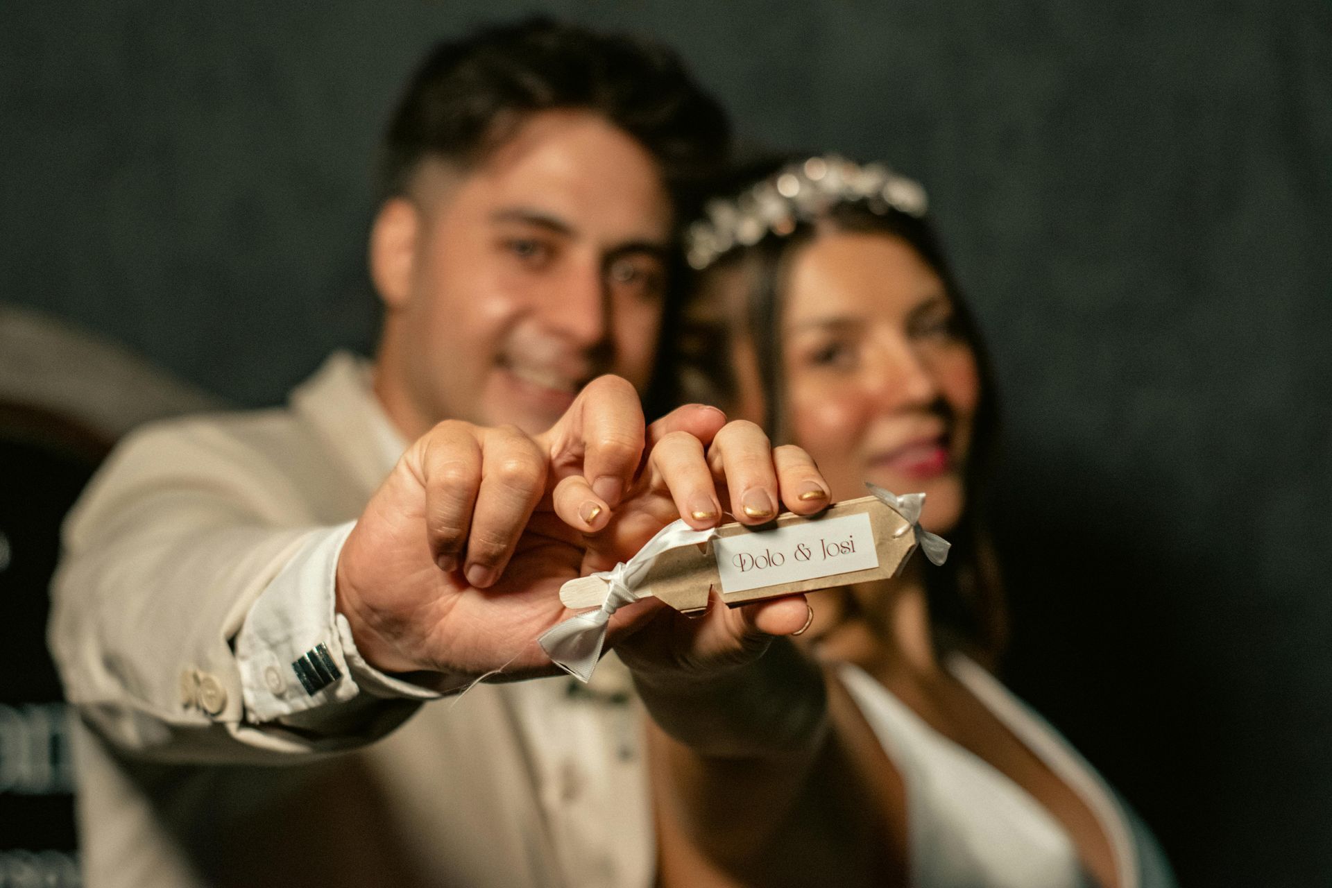 Pareja sosteniendo una etiqueta que dice 