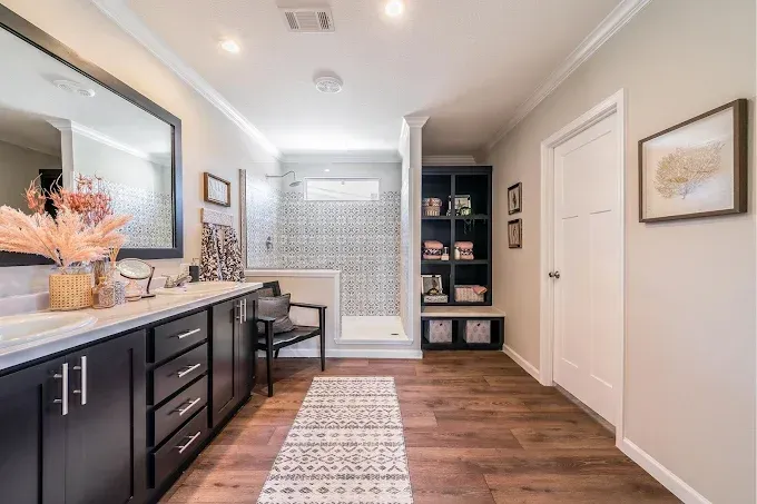 Spacious bathroom with double vanity, walk-in shower, wood floor, and neutral decor