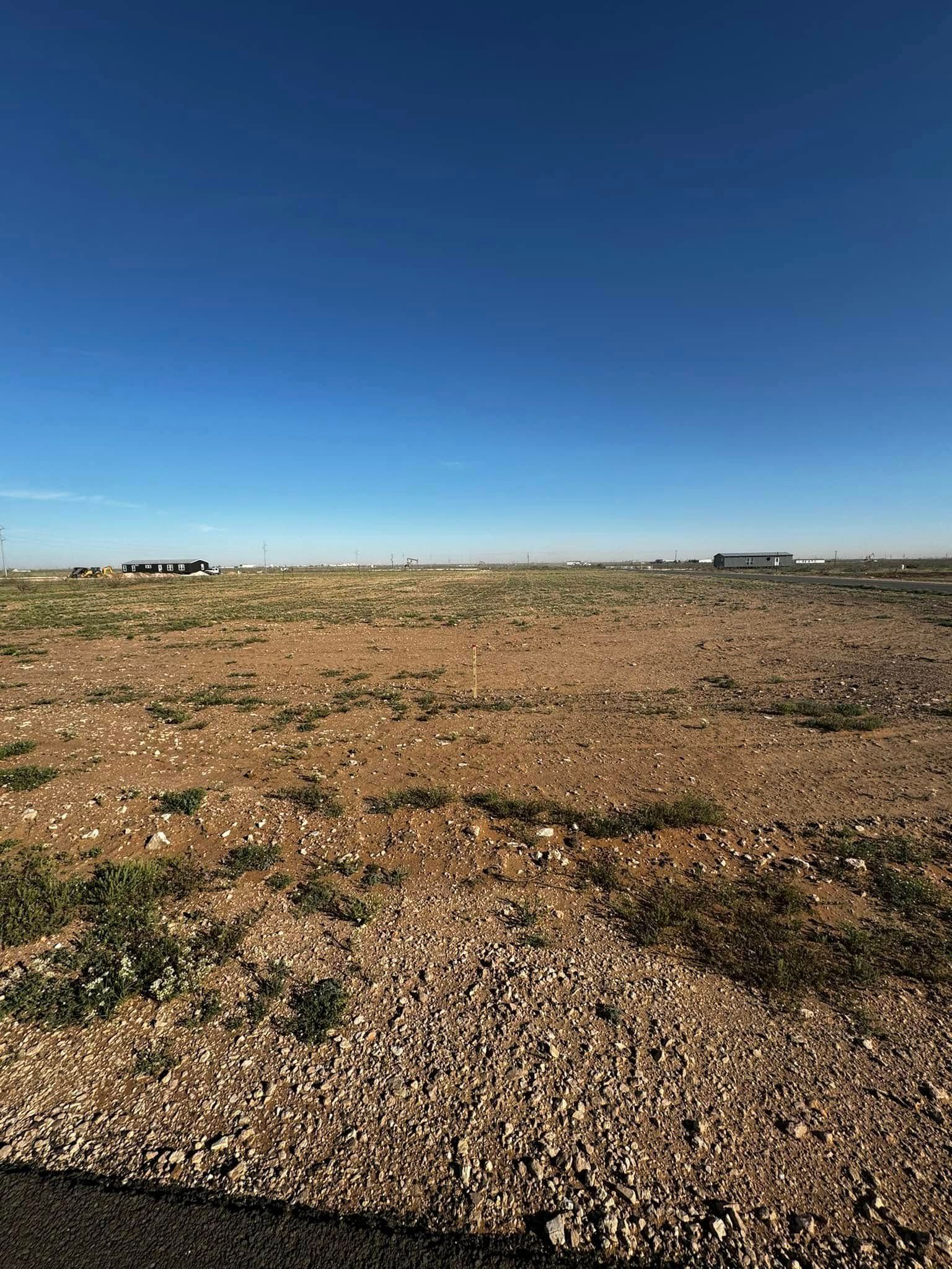 Rocky desert plain under a clear blue sky with a distant horizon