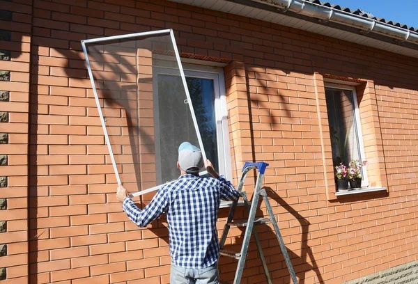 Corona Screen Repair Technician replacing a window screen with new custom built frame and screen