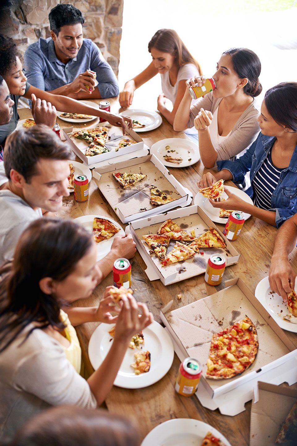 Pizza, restaurant and friends party at table eating together with social, communication and conversation for reunion or celebration. Happy group of people with fast food, soda and lunch in cafeteria