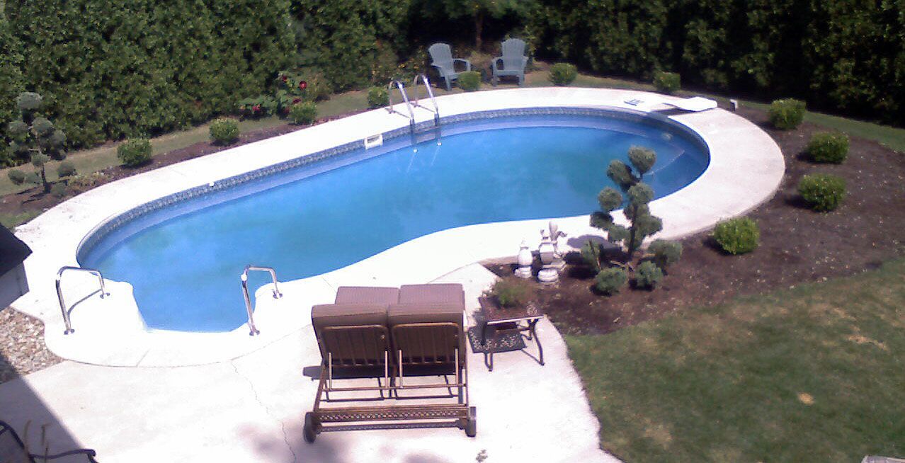 An aerial view of a large swimming pool in a backyard.