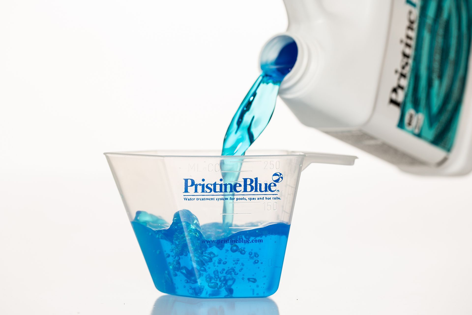 A bottle of pristine blue is being poured into a measuring cup