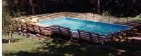 An aerial view of a large swimming pool surrounded by trees.