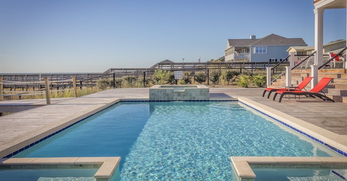 There is a large swimming pool in the backyard of a house.