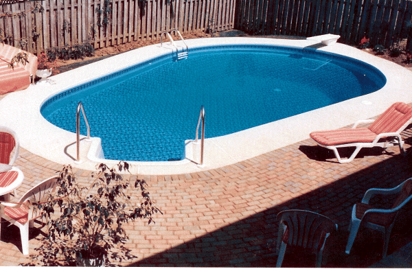 A large oval swimming pool is surrounded by chairs and a fence