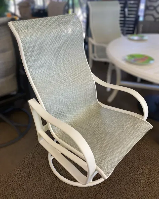 A White Rocking Chair Is Sitting in Front of A Table