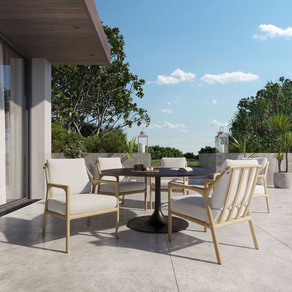 A table and chairs on a patio with trees in the background