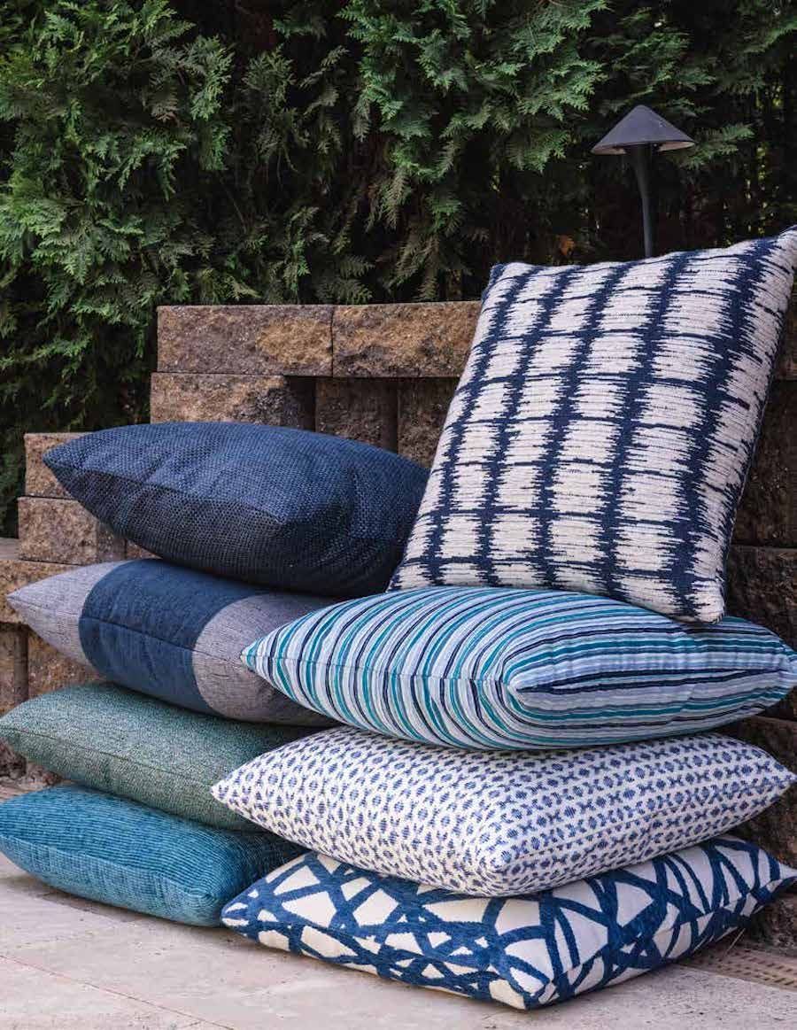 A stack of blue and white pillows sitting on top of each other.