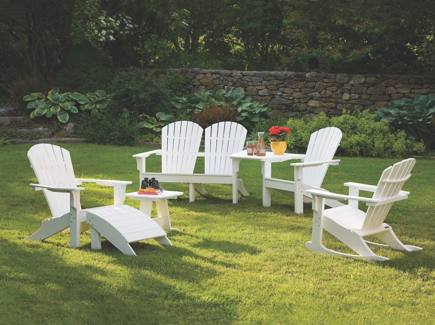 A group of white chairs are sitting on a lush green lawn.
