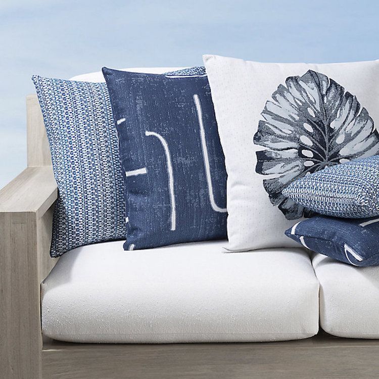 A white couch with blue and white pillows on it
